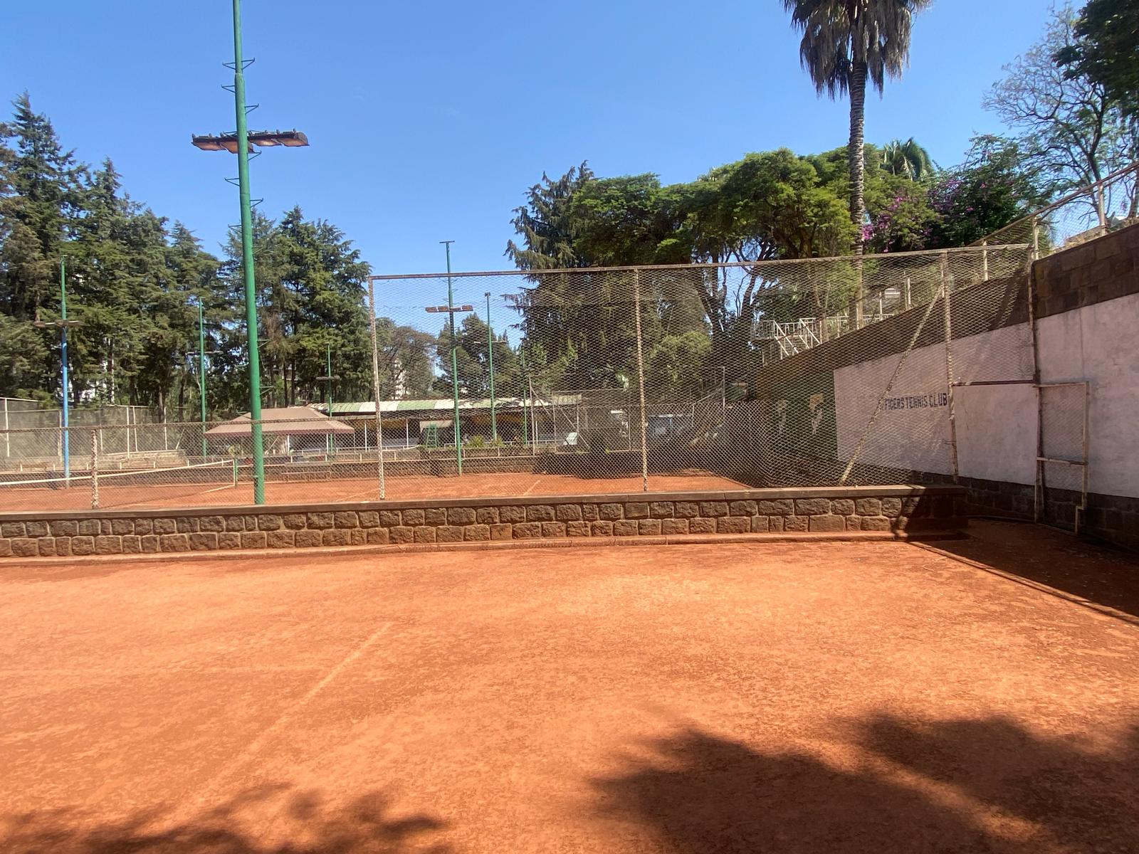 Clay tennis court at Mekonenoch Club under clear skies